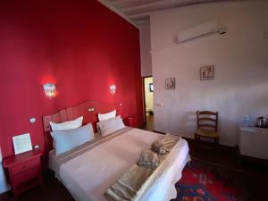 隆达La Guzmana de Ronda的红色的卧室设有一张白色的床铺和红色的墙壁