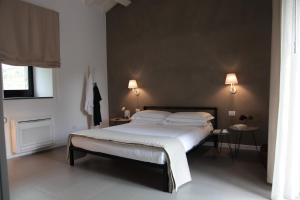 皮耶迪蒙泰埃特内奥故事餐厅及套房度假酒店的一间卧室配有一张床、两张桌子和两盏灯。