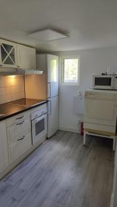 GustavsvikMinivilla in Gustavsvik Nacka的厨房配有白色橱柜和白色冰箱。
