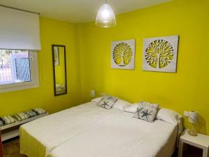 贝尼卡洛UMA luna al sol Benicarlo-Peñiscola的一间卧室设有一张黄色墙壁的大床