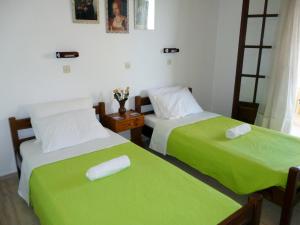 阿里拉斯Villa Helen的配有绿床单的客房内的两张床