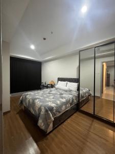 泗水DeAr Caspian Apartment的一间卧室设有一张床和玻璃墙