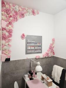 Villa BadessaAndale SuiteSpa的墙上挂着粉红色花的沙龙