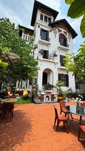 河内Tuna Homestay Hanoi & Experience的前面有桌椅的房子