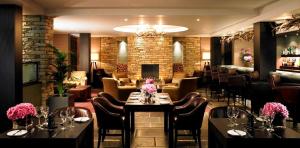 克鲁Wychwood Park Hotel and Golf Club的一间带桌椅的餐厅和一间酒吧