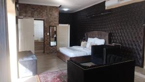 内尔斯普雷特Naldorado Executive Villa的一间卧室设有一张床和砖墙