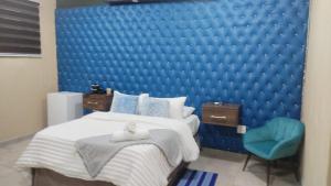 内尔斯普雷特Naldorado Executive Villa的一间卧室配有蓝色的墙壁、一张床和一张蓝色的椅子