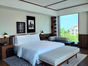 青岛青岛福楼安可傲途格精选酒店的一间卧室设有一张大床和一个大窗户