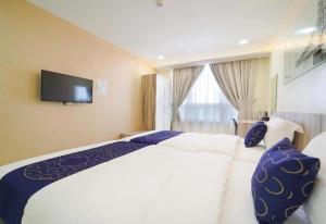 大山脚OYO 90975 Atta Hotel的酒店客房设有一张床铺,墙上配有电视。