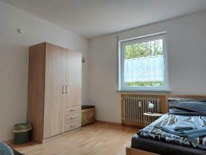 HardtGästehaus Walter的一间卧室配有床、橱柜和窗户