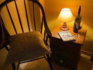 特雷索波利斯Pousada Jardim Secreto的桌椅、灯具和一瓶葡萄酒
