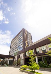TobadiSuni Hotel and Convention Abepura managed by Parkside的一座大建筑,上面有金色标志