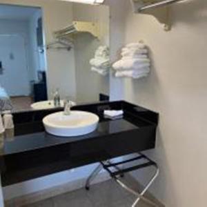 范霍恩范霍恩6号汽车旅馆的浴室设有黑色的吧台、水槽和镜子