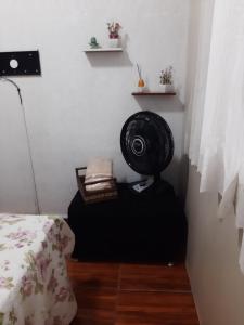 尼泰罗伊Loft aconchegante - Centro Niterói的一间位于地板上的客房,配有一张床和风扇