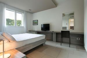 马拉内罗洛坎达拉卡泽拉酒店的一间卧室配有一张床和一张书桌及电视