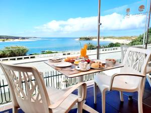 米尔芳提斯城Hotel HS Milfontes Beach - Duna Parque Group的阳台上的餐桌和食物,享有海景
