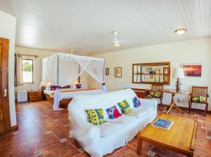 迪亚尼海滩Flamboyant Diani Beach的客厅配有白色的沙发和床。