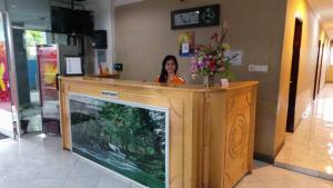 卢武克卡拉通卢乌克酒店的站在一个有大鱼缸的柜台后面的妇女