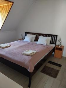 博加奇Pipacs Vendégház的一间卧室配有一张大床和两条毛巾