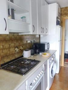 纳瓦尔卡内罗3 bedrooms apartement with furnished terrace and wifi at Navalcarnero 5 km away from the slopes的厨房配有白色橱柜和炉灶烤箱。