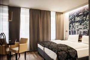 慕尼黑慕尼黑城中心赫尔维蒂亚酒店的酒店客房设有一张床、一张书桌和窗户。