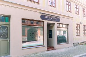 奎德林堡Ferienwohnungen Steinweg 61的建筑物一侧有标志的商店前部