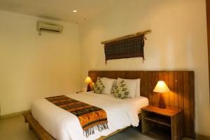 勒吉安米娜佩拉萨酒店的一间卧室配有带白色床单和枕头的床。
