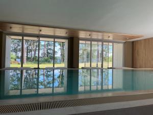 巴特萨罗皮斯库夫My Marina Apartment mit Pool und Sauna am See的一座带玻璃窗的建筑中的游泳池