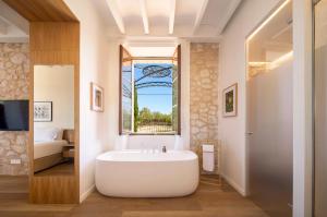 蒙图伊里Es Figueral Nou Hotel Rural & Spa - Adults Only - Over 12的带浴缸的浴室和窗户