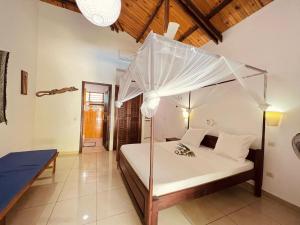 贝岛Résidence Kambana的卧室配有带雨伞的白色床
