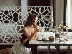 拉巴特拉巴特索菲特玫瑰园酒店的坐在餐桌上吃一盘食物的女人