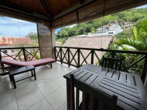 贝岛Résidence Kambana的阳台的门廊配有长凳和桌子
