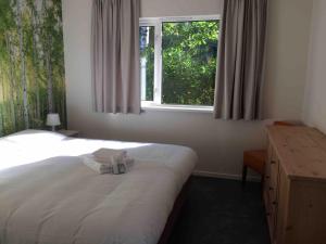 HaelenLandgoed Leudal的一间卧室配有一张带窗户和毛巾的床