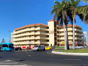 英格兰海滩Tanife 310 - Playa del Ingles comfort Suite with Sunset view的停车场内停放汽车的大型建筑