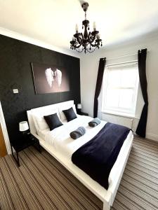 伯恩茅斯竹酒店的一间卧室配有一张大床和一个吊灯。