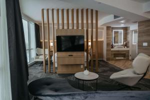 肯诺拉克拉丽奥湖畔会议中心酒店的客厅配有电视、沙发和桌子