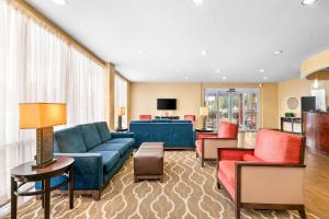 奥兰多奥兰多机场舒适套房酒店的客厅配有蓝色的沙发和红色的椅子
