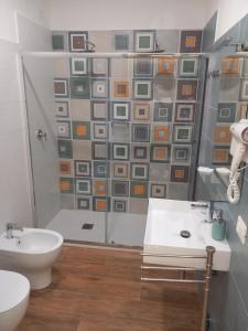 阿格罗波利Qvattro stagioni panoramic suites的带淋浴、卫生间和盥洗盆的浴室