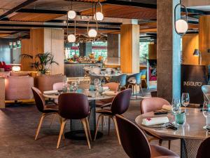 马德里Ibis Styles Madrid City Las Ventas的一间带桌椅的餐厅和一间酒吧
