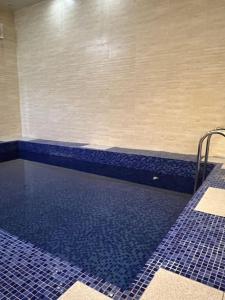 Al Faltشاليهات توليب的浴室设有蓝色瓷砖,设有游泳池