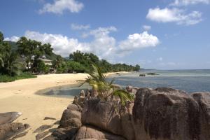 Pointe Au Sel 塞舌尔皇冠海滩酒店的一个带岩石墙的海滩和大海