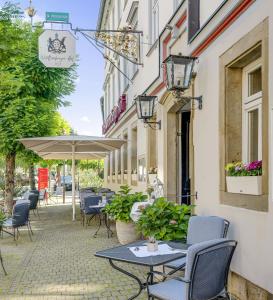 厄林根福滕伯格霍夫酒店的一个带桌椅和遮阳伞的庭院
