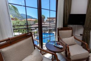 厄吕代尼兹杜高斯布提克公寓式酒店的一间带两把椅子和一张桌子的客厅以及一个阳台