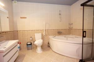 厄吕代尼兹杜高斯布提克公寓式酒店的带浴缸、卫生间和盥洗盆的浴室