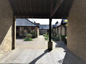 BovingdonCosy Barn Conversion Bedroom & En Suite的庭院中带凉亭的砖砌建筑