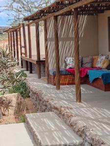 KotzesrusNuwefonteinskop Lodge的门廊上设有床和长凳