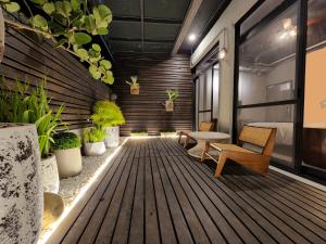 台南The Retro Tai-Pan的客房设有带椅子和植物的木制甲板。
