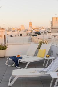加的斯Candelaria10的阳台配有白色椅子,享有城市美景