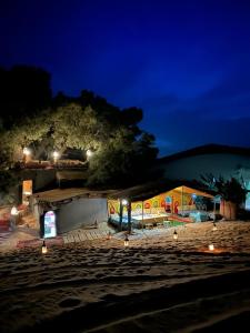AdrouineTamaris Camp的海滩上晚上灯的建筑