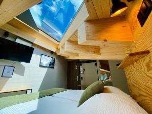 采尔马特Peaky Riders Self Check-in Hotel的一间卧室设有一张带窗户的天花板和一张床铺